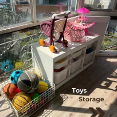 A dedicated storage unit for toys, with open bins for easy access and a basket for balls, keeps the play area tidy.