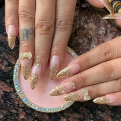 Learn how to create glamorous looks like this gold glitter gradient on almond-shaped extensions, finished with delicate 3D bow and rhinestone embellishments.