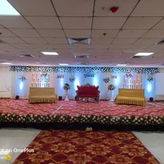 For larger stages, I can create a wide, expansive backdrop. This setup includes a central red sofa for the main couple and two smaller golden sofas on the sides for family, ensuring everyone is part of the picture.