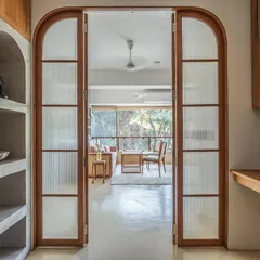 I love creating spaces that can adapt to your life. For this nutrition clinic, I designed these arched, fluted glass doors to beautifully separate the main living area from the workspace, allowing it to transform into a cozy bedroom at night.