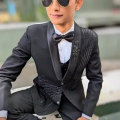 A sharp, modern black tuxedo for the man of the hour. This three piece suit features unique beaded detailing on the lapel and jacket, making it a standout choice for receptions, cocktail parties, or any formal event.