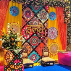 This is not your average Haldi decor. For this event, we designed a vibrant, Rajasthani-inspired backdrop using colorful printed panels, mandala art, and the word "Haldi" crafted from fresh marigold flowers. It’s a perfect example of how we mix traditional elements with modern design.