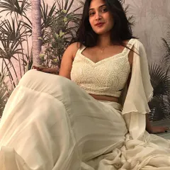 A serene shot of our off-white fusion set, featuring a fully beaded crop top and a flowing tiered skirt with a pre-attached ruffled dupatta.