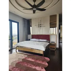 This master bedroom features a custom bed with a striking brass frame and a deep red velvet headboard. The design is complemented by a kinetic wall sculpture and integrated side tables, creating a look that is both luxurious and artistically curated.