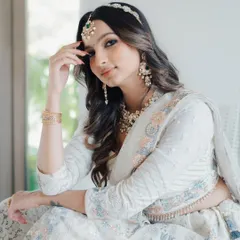 A relaxed and elegant pose, this shot highlights the beauty of the full set, including the maang tikka and matching earrings.