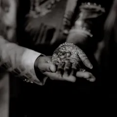 A dramatic black and white shot of the wedding rings resting in the groom's hand. This artistic photo emphasizes the sanctity and importance of the rings as symbols of commitment.