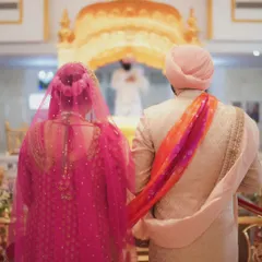 United in faith. This shot from behind the couple during their Anand Karaj ceremony highlights their connection and the spiritual significance of the moment.