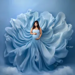 A full-length view of this incredible light blue gown, where the fabric itself becomes a work of art. The way it billows and flows creates a stunning, ethereal maternity portrait.