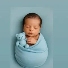 Snuggled in a cozy blue wrap with a tiny teddy bear, this little one is the picture of peaceful sleep. I use simple, sweet props to add a touch of personality while keeping the focus entirely on your baby's adorable features.