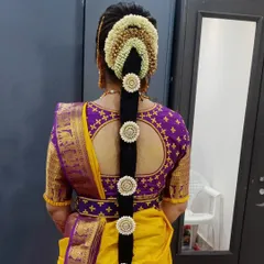 My specialty, the traditional Poola Jada. This intricate floral hairstyle uses fresh flowers and classic hair jewelry, making it a timeless choice for a South Indian bride.