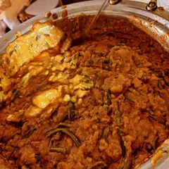 A close-up of a traditional Kutchi Memon curry being served at a Mehandi function. This hearty, vegetable-rich dish is a staple in our wedding catering menus.