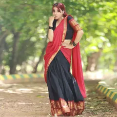 This full-length shot of the half-saree shows how the red dupatta and black skirt create a beautiful contrast. The outdoor park setting in Bangalore provides a simple, natural backdrop.