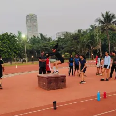 A female athlete executes a perfect box jump during a training session on our track. This exercise, overseen by one of our coaches, is fundamental for developing power and agility, highlighting the professional-level athletic training we offer.