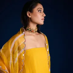 A beautiful close-up portrait from the Aapro shoot, where the rich blue background complements the vibrant yellow of the ethnic wear.