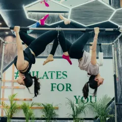 This inverted partner pose on the Cadillac showcases amazing strength, flexibility, and trust. It's a beautiful example of advanced Pilates artistry.
