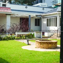 I design complete residential landscapes that feel like a private retreat. Here, a healthy, expansive lawn is the centerpiece, complemented by a rustic stone well, carefully planned garden beds, and pathways that invite you to explore the space.