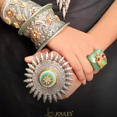 Boldness crafted in silver. This oxidized kada and oversized ring are for the woman who wears her heritage with modern confidence. The intricate carvings and gemstone accents make these pieces a testament to powerful, statement-making design.