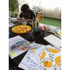 A participant immersed in a calligraphy session, with practice sheets and colorful pens spread across the table. My workshops are designed to provide a therapeutic escape through focused, creative tasks.