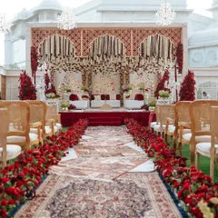 The aisle for Naomi and Rakshit's 'Laal Ishq' wedding, leading to a magnificent mandap. We used a series of ornate Persian rugs for the walkway, bordered by a dense arrangement of red roses, setting a regal tone for the ceremony.