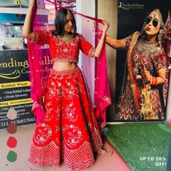 Try on your dream red bridal lehenga at my store. This piece features beautiful floral embroidery and is perfect for the main wedding ceremony.