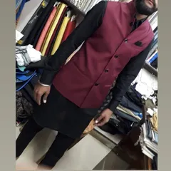A client in my shop wearing a custom-fit maroon Nehru jacket over a black kurta set. This color combination is bold and sophisticated.