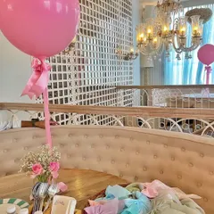 Table setting for the bridal shower, featuring a large pink balloon and a small floral arrangement. Even small details are coordinated to create a cohesive and beautiful event space.