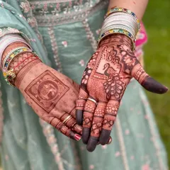 A beautiful combination of motifs on each hand. One palm features a traditional elephant design, while the other showcases an elegant peacock, giving the bride a unique and varied look.