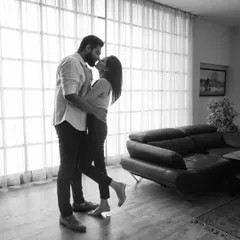A classic, timeless moment captured in black and white. The soft light from the window and their gentle embrace create a feeling of pure romance. This kind of intimate portrait focuses solely on the emotion and connection between two people.