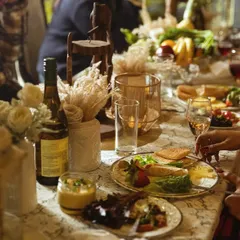 A beautifully plated meal being enjoyed at a candlelit dinner. The table setting includes rustic decor elements like dried pampas grass and wooden accents, creating a warm and inviting atmosphere.