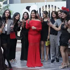 The bride-to-be surrounded by her tribe, all raising a custom shot in her honor.