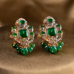 The Aurora Verde earrings, designed to be bold yet elegant. The central emeralds are framed by diamonds and accented with delicate emerald beads, creating movement and a rich, verdant statement perfect for a discerning bride.