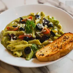 A close-up shot of a creamy pesto pasta dish, ready to be eaten. I focus on making the food the hero, using natural light and careful composition to emphasize its delicious details.