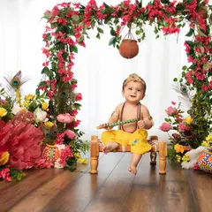 With a flute in hand and a hanging matki above, this little Krishna is ready for some mischief. The floral arch creates a beautiful frame for this festive shot.