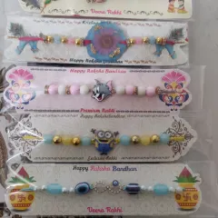 I also make fun rakhis for the little ones. This picture shows some of my kids' collection, including Tom and Jerry and Minion designs, alongside a Krishna-themed rakhi.