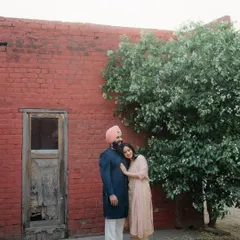 A tender moment against a rustic red brick wall in old Amritsar. We love finding beauty in historic textures and colors to create timeless couple portraits that feel both authentic and artistic.