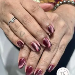 This deep raspberry cat-eye polish has a beautiful pink shimmer that catches the light. It's a great choice for a look that's both dark and vibrant.