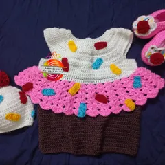 A sweet cupcake-themed dress set, complete with a sprinkle-covered hat and matching pink shoes. This is one of my most requested custom crochet baby outfits, ideal for making any day feel like a celebration.