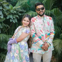 A cool and stylish portrait of the couple. The bride-to-be's makeup is fresh and modern, matching their coordinated floral outfits.