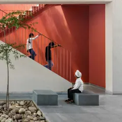 We use color to define spaces and create visual interest. The bright red wall draws you up the stairs and adds a burst of energy to this central courtyard at the St. Martha Bethany Vidyalaya school.
