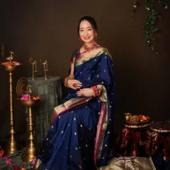 The full traditional look. This portrait showcases the beautiful details of the Paithani saree, the floral jewelry, and the classic brass decor, creating a rich and soulful atmosphere.