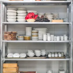 The heart of our operations lies in organization and preparation. These shelves hold our custom crockery and tools, all meticulously arranged and ready for a busy service.