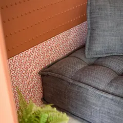 A close-up of the reading nook, showing the beautiful contrast between the textured grey fabric of the lounger and the patterned tiles at the base.