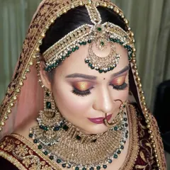 This is my signature bridal makeup style. It features a warm, sunset-toned halo eye, perfectly defined brows, and a flawless base. This look is paired with heavy emerald and gold jewelry for a truly royal effect.