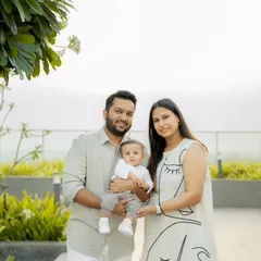 A modern family portrait taken on a rooftop with lush greenery in the background. This is a great option for a clean, contemporary outdoor look.