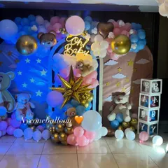 This 'Oh Baby' shower decoration uses a dreamy blue, pink, and gold color scheme. The setup includes arched backdrops with star details, multiple teddy bears, and transparent 'BABY' blocks filled with balloons.