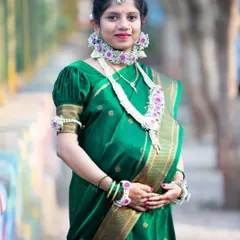 A radiant mom-to-be dressed for her baby shower ceremony. The green saree and intricate floral jewelry create a stunning and traditional look for this special occasion.