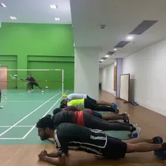 Core strength is the foundation of a powerful badminton player. Our adult shuttlers hold their planks, building stamina and stability while a match plays out in the background.