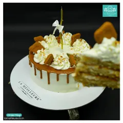 Our Lotus Biscoff cheesecake ready for a celebration, complete with a candle. A slice has been cut to show the delicious layers inside.