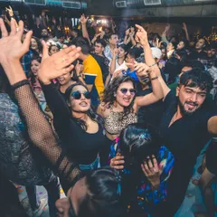 A packed dance floor with everyone smiling and dancing. The energy is infectious, and it's what I feed off all night.