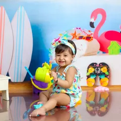 This little beach-goer is all smiles with her watering can. My indoor beach theme brings the sun and sand to the studio, any time of year.